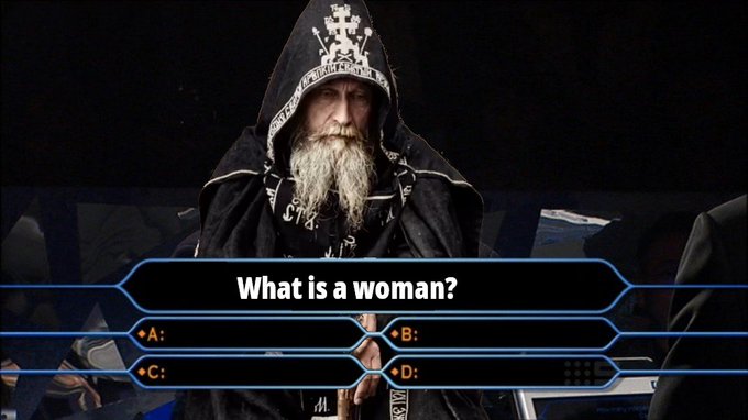A hooded wizard-like figure with a long white beard appears on a game show screen posing the question "What is a woman?" with multiple choice options A, B, C, and D.