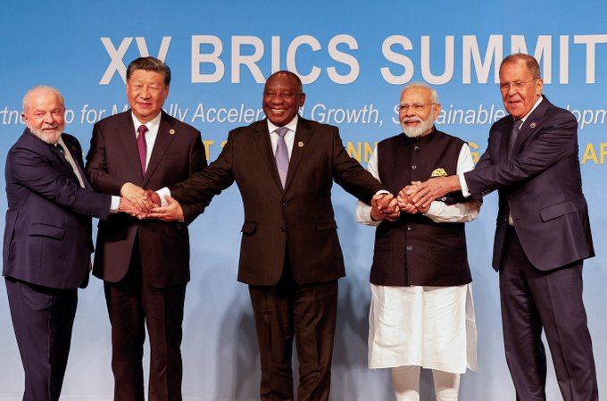Leaders of BRICS nations, including Luiz Inácio Lula da Silva, Xi Jinping, Cyril Ramaphosa, Narendra Modi, and Sergey Lavrov, are shown at the XV BRICS Summit. The image visually represents the BRICS group whose members are discussing faster and cheaper cross-border payments through fast-payment systems and CBDCs.