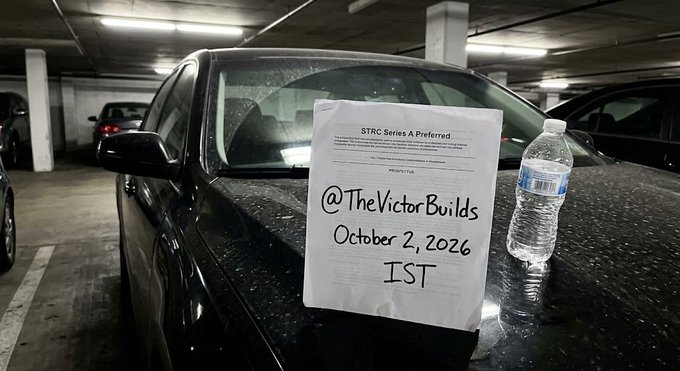 A handwritten sign propped on a black car's windshield in an underground parking garage announces "@TheVictorBuilds October 2, 2026 IST" above an STRC Series A Preferred document, with a water bottle beside it. The image relates to the post by visually marking the date Strategy confirmed the 12% STRC preferred dividend, symbolizing the "Trojan Horse" for TradFi liquidity entering Bitcoin.