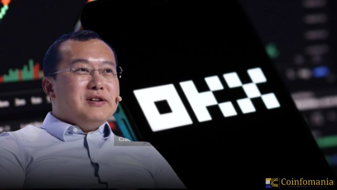 A man in glasses and a light blue shirt speaks at a Crypto event, with the OKX logo prominently displayed beside him and the Coinofomania watermark in the corner. The image illustrates the post's warning about OKX's CEO Star Xu and the exchange's policy of freezing user funds for up to a month when deposits originate from flagged "high-risk" addresses.