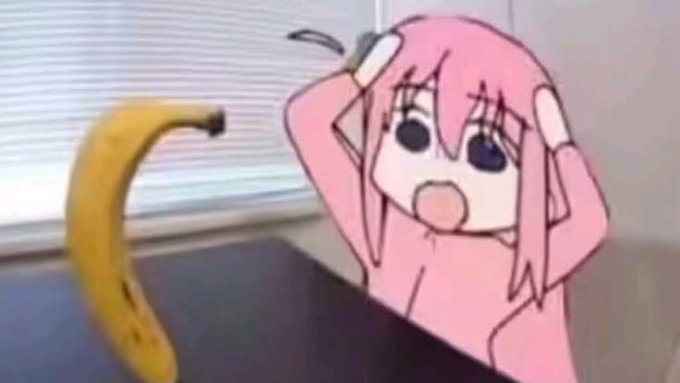 A meme combining a real banana on a desk with an anime character (Bocchi the Rock) reacting in shock, hands raised to their face.
