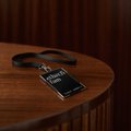 A dark-toned image showing what appears to be a card or small item resting on a round wooden table.