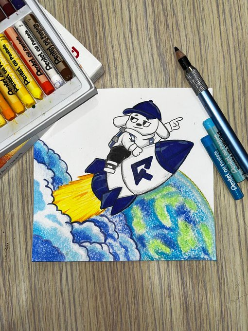 A creative drawing of a cartoon dog character wearing a cap riding a rocket through clouds above Earth, created with Pentel oil pastels and pencils on a wooden surface.