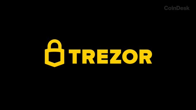 The image displays the yellow Trezor logo, featuring a padlock icon, on a black background with a "CoinDesk" watermark in the top right corner. The Trezor branding directly relates to the accompanying post about an expanded data breach affecting the hardware wallet company's customers, where the padlock imagery underscores the security concerns raised in the alert.