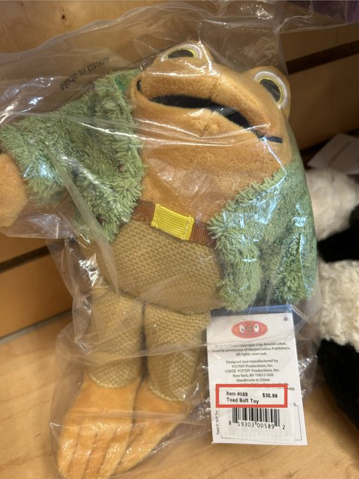 A plush Toad of Toad Hall toy is shown in its original packaging on a wooden surface, priced at $30.99, with the XRP community humorously noting that Mr. Toad is sporting a "massive XRP bag" around his waist—poking fun at the frog-like mascot appearing to sport a money bag like a bullish crypto investor.