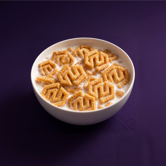 A bowl of geometric-shaped cereal sitting in milk on a purple background. The post "GM! Who wants a bowl?" plays on the cereal being a cheeky reference to "having a bowl" of crypto/NFT collectibles — aligning with the "GM" (good morning) greeting popular in web3 and NFT communities.
