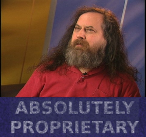 A man with long dark hair and a gray beard wearing a red button-up shirt, with a purple banner at the bottom displaying the text 'ABSOLUTELY PROPRIETARY'.