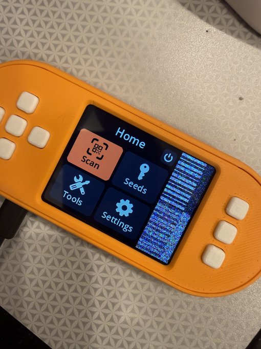 The image shows a SeedSigner Plus device displaying its "Home" menu with options for Scan, Seeds, Tools, and Settings, while the right side of the screen shows a scrambled/glitched display pattern. The caption could read: "Close-up of a SeedSigner Plus on the Home menu (version 0.8.7pi0.img), showing a distinctive glitched/scrambled strip on the right side of the display."