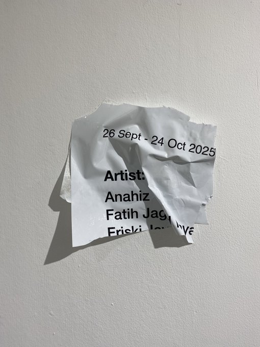 A crumpled piece of paper taped to a white wall displays an exhibition notice with dates '26 Sept - 24 Oct 2025' and partially visible artist names 'Anahiz', 'Fatih Jag', and 'Ericki' followed by torn paper.