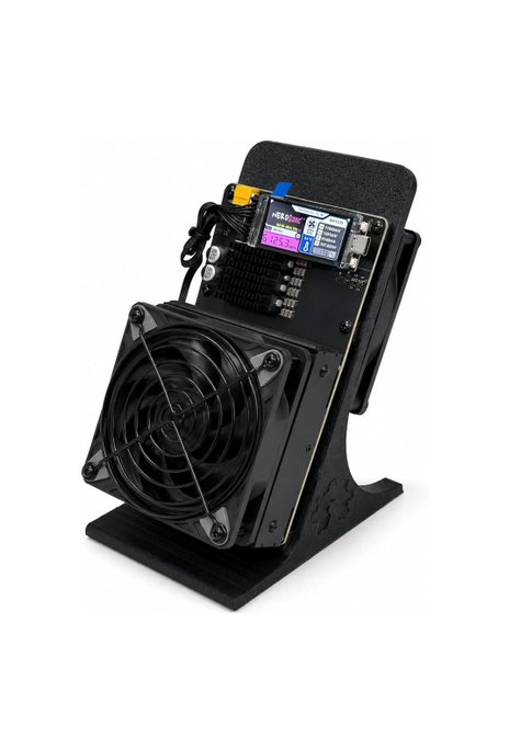 A close-up of a Bitaxe solo Bitcoin miner with a cooling fan and OLED display showing hashrate data, representing the compact hardware used by the lucky miner who discovered a $200K Bitcoin block. The device, likely rented at 100PH for $25K weekly, illustrates the specialized equipment behind this rare solo mining success.