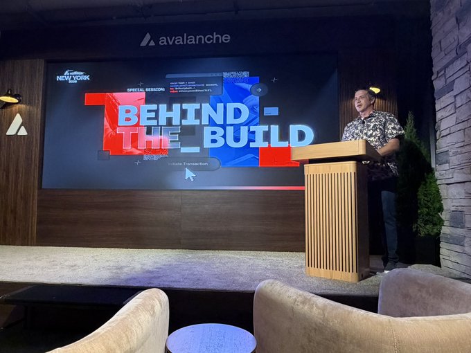 A man giving a presentation at a podium in front of a large screen displaying 'BEHIND THE BUILD' and 'SPECIAL SESSION' with the Avalanche logo and 'Avalanche New York' branding.