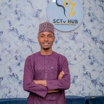A young man in a purple traditional outfit stands with arms crossed in front of the "SCTV HUB" logo, likely representing the crypto-focused media hub featured in the post highlighting his leadership in launching a Solana-based token without rugging or dumping on his community.