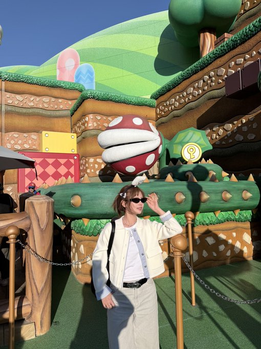 A person posing in front of a Super Mario Bros. themed piranha plant structure, likely at Universal Studios Japan.