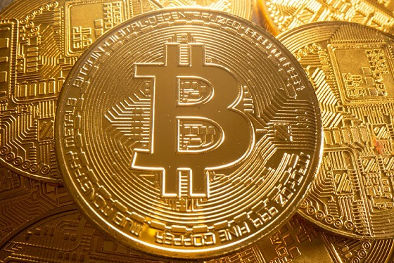 The image features a close-up view of a gold coin with the Bitcoin symbol on top. The coin appears to be made of metal and has a shiny appearance due to its golden hue. The text accompanying the image reads "*STRATEGY $MSTR RESUMES #BITCOIN BUYING SPREE, QUELLING MARKET PANIC". This suggests that someone is promoting Bitcoin as an investment strategy or discussing the potential benefits of investing in Bitcoin.