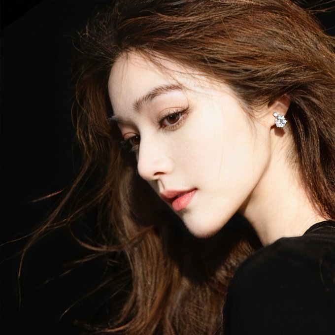 A close-up portrait of a young woman with long brown hair, wearing flower-shaped stud earrings, soft makeup, and red lipstick against a dark background.