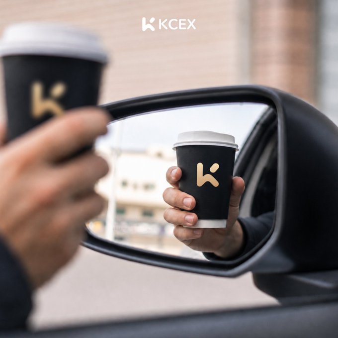 A promotional image for KCEX featuring a hand holding a black coffee cup with a gold 'K' logo reflected in a car's side mirror.