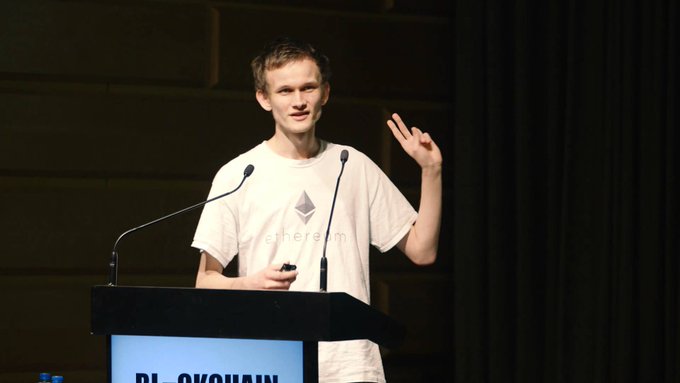 Vitalik Buterin, creator of Ethereum, speaking at a podium while wearing an Ethereum t-shirt.