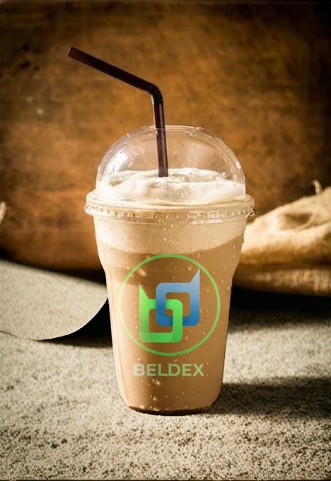 A plastic cup of iced coffee with a black straw, displaying a green and blue logo for 'BELDEX' on the front, sitting on a textured fabric surface with a burlap background.