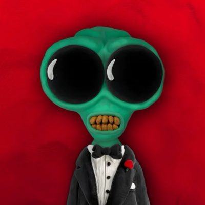 A digitally illustrated green alien with large black eyes and yellow teeth, dressed in a formal tuxedo with a black bow tie and a red rose boutonnière against a red background.