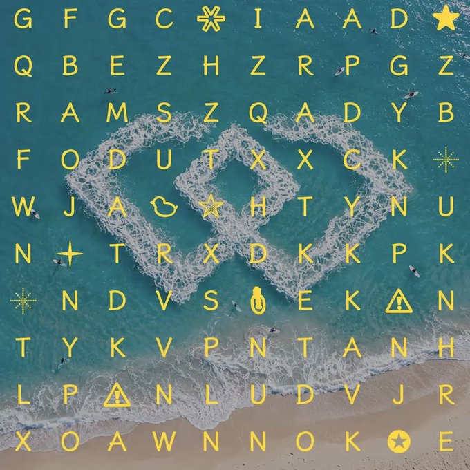 An aerial view of ocean waves crashing on a beach, overlaid with a grid of yellow letters and symbols, including a star and a heart shape made from the white foam.