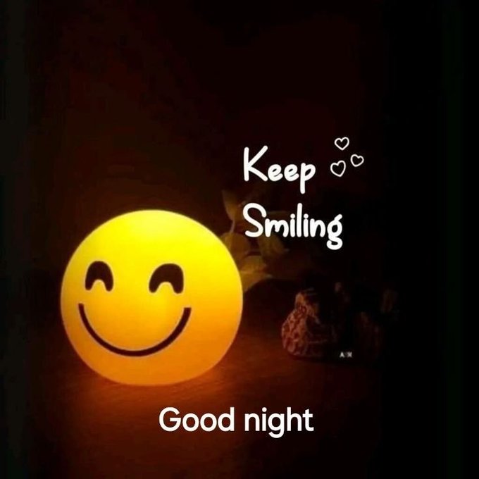 A glowing yellow smiley face lamp in a dark setting, accompanied by the text 'Keep Smiling' with small heart drawings and 'Good night' below.