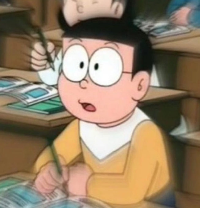 An anime character with round glasses, black hair, and a yellow shirt holding a pen, appearing surprised or excited in a classroom setting.