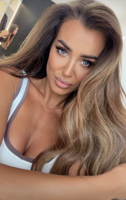 A close-up selfie of a woman with long brown hair and a white top, accompanied by the caption "GM people #Crypto."