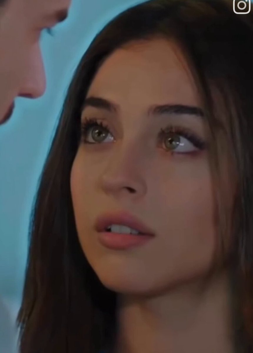 The image features a woman with long brown hair, looking at another person who has short brown hair. The woman's face appears sad or thoughtful as she gazes into the distance. There are no texts or other objects present in the scene.