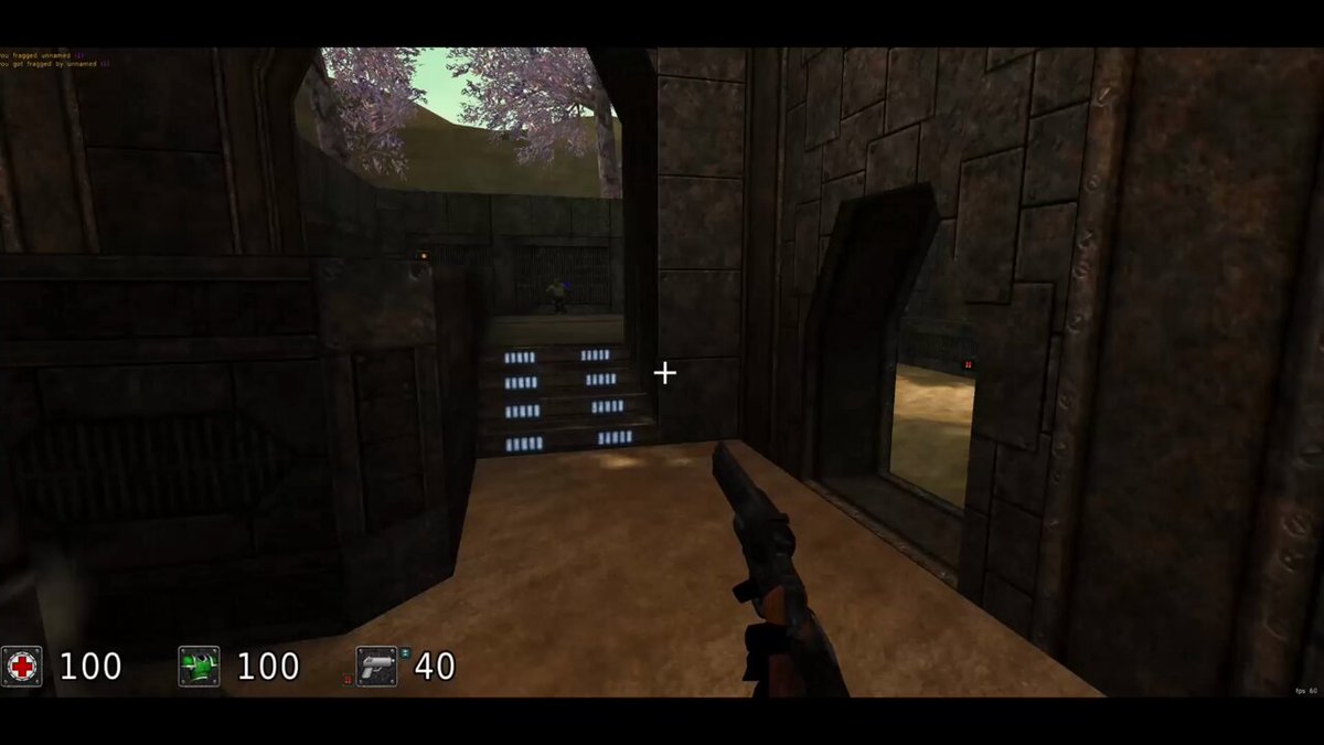 The image shows a video game scene with a character standing in front of a stone wall, holding a gun. The player's score is displayed at the bottom left corner of the screen, indicating their performance in the game. The game appears to be a first-person shooter or action roleplaying game (FPS), as suggested by its title and gameplay elements. The player has 100 points, 40 health, and 20 lives remaining.