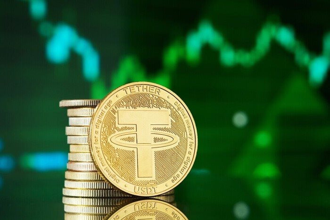 A close-up of stacked gold Tether (USDT) cryptocurrency coins displayed against a green stock chart background.