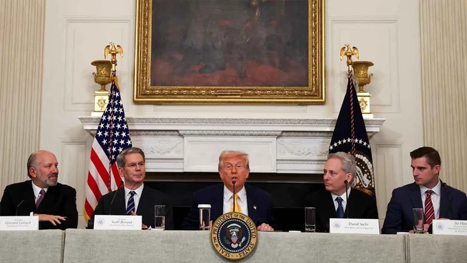 President Trump sits at the center of the White House Cabinet Room table during a meeting with SEC Chairman Paul Atkins and others, with name placards identifying attendees including "Howard Lutnick" and "Scott Bessent" visible in the foreground. The setting, featuring the presidential seal and American flags, relates to the post by depicting a high-level policy gathering at the White House ahead of the announced crypto summit involving Trump, regulators Atkins and Selig, and major industry CEOs.