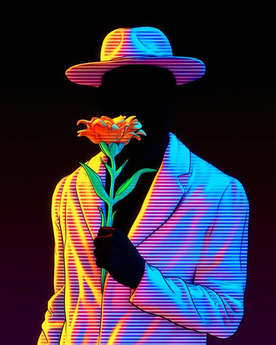 The image features a man wearing a hat and holding an orange flower above his head. The background of the image is black, which contrasts with the bright colors of the flower and the man's attire. The caption at the bottom of the image reads "ITIA night great day it was,we all did our best. See y'all tomorrow @quipnetwork Art by @IThinkItsArt".