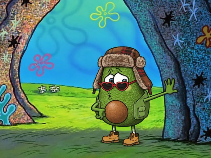 A cartoon pickle character wearing an aviator hat with ear flaps, heart-shaped sunglasses, and tan boots stands in front of a cave entrance decorated with flower shapes against a blue sky with a distant green landscape.