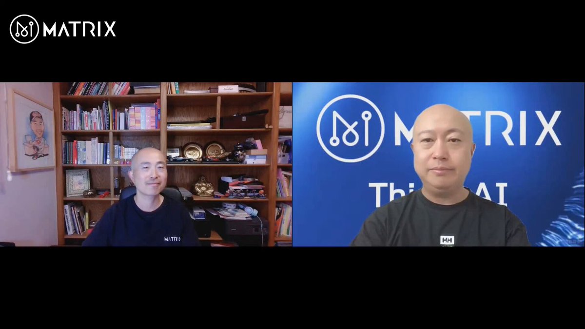 The image shows two men sitting at a desk, both wearing black shirts. They are facing each other across a table, engaged in an interview or discussion. The background of the image features a blue banner with the Matrix logo displayed above them.