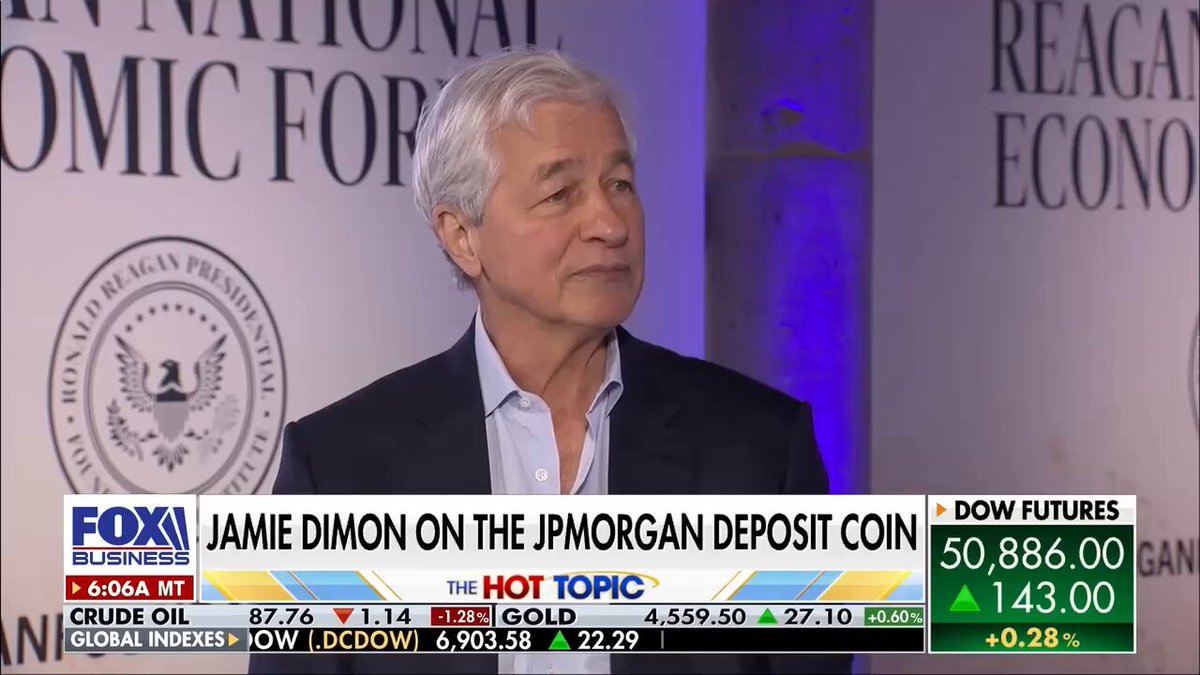 The image shows a man wearing a suit standing against a backdrop that includes a banner for Fox Business and an economic forecast. The man appears to be speaking at a press conference, as indicated by his body language and facial expressions. He is talking about banks and their plans to fight the clarity act, which could potentially impact the stock market. The image also contains some text related to cryptocurrency, specifically mentioning Brian Armstrong's name.