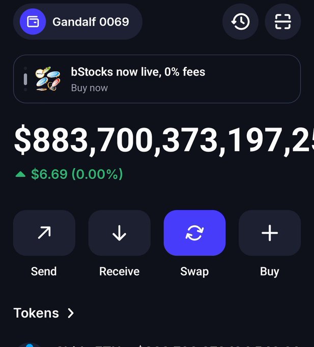 Crypto wallet app showing account 'Gandalf 0069' with a balance of $883,700,373,197,2[5], up $6.69, featuring Send, Receive, Swap, and Buy buttons, with a banner ad for 'bStocks now live, 0% fees'.