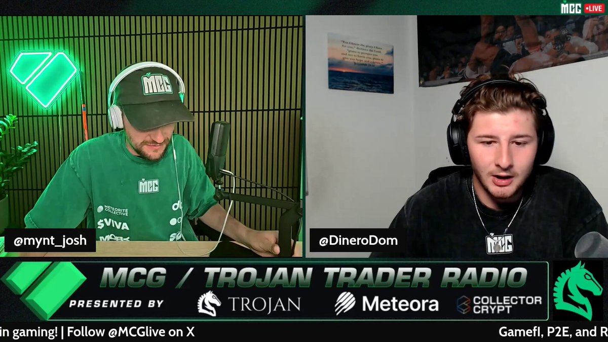 The image features two men sitting behind a green microphone, having a conversation. They are discussing a radio show called "MCG" featuring a Trader Radio segment titled "Troy Trader Radio". The show is played by the DJ team, who are responsible for hosting and managing the podcast content. The hosts discuss various topics related to cryptocurrency trading and gaming, such as the metaverse, new game features, and their continuous development process. They also ensure that upcoming new features have been approved by @Steam, and the 30-day upload process is underway for the segment.