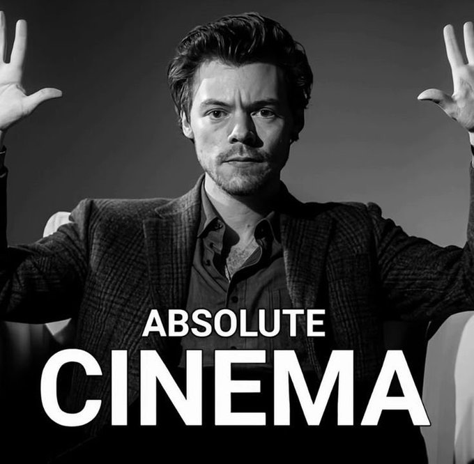 A black-and-white photo shows a man with tousled hair and a checkered blazer raising both hands in an expressive gesture, with bold white text overlaid reading "ABSOLUTE CINEMA." The dramatic pose and enthusiastic caption emphasize triumph and excitement, aligning with the post's declaration that "we're back" despite doubters.