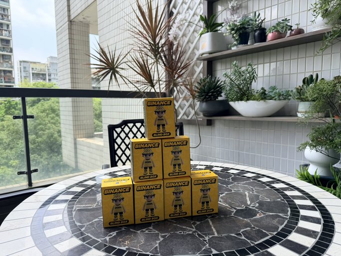 The image features a table with several boxes of toys, including action figures, stacked up against each other. The toys are yellow and black, which adds a pop of color to the scene. In addition to the toys, there are potted plants placed around the room, adding greenery to the space. A chair is also visible in the background, suggesting that this setup could be part of a living or playroom area.

The post about action figures and toys seems to be related to the items on display, possibly discussing their value or significance. The image captures an interesting moment where these toys are displayed together, creating a visually appealing scene for viewers.