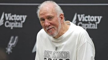 The image shows Gregg Popovich, head coach of the San Antonio Spurs, smiling during a press conference with "Victory Capital" sponsorship logos visible on the backdrop behind him. The caption "Karma" fits the image as Popovich's relaxed, confident smile suggests he may be reflecting on favorable outcomes or poetic justice following recent events.