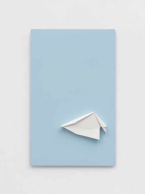 A minimalist art poster featuring a white paper airplane centered on a pale blue background, presented as a sculpture available for $8,800 to support earthquake relief efforts in Colombia.