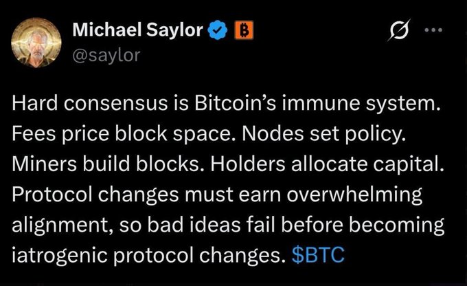 A tweet from Michael Saylor (@saylor) reads: "Hard consensus is Bitcoin's immune system. Fees price block space. Nodes set policy. Miners build blocks. Holders allocate capital. Protocol changes must earn overwhelming alignment, so bad ideas fail before becoming iatrogenic protocol changes. $BTC"

The image directly supports the accompanying post's thesis about Bitcoin's security being a "social contract," illustrating Saylor's framing of hard consensus as the network's immune system maintained by independent nodes, miners, and holders.