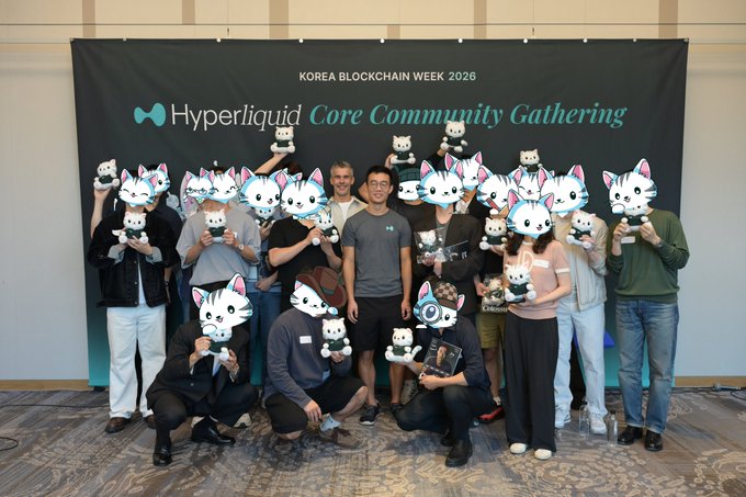 A group photo from the Korea Blockchain Week 2026 Hyperliquid Core Community Gathering, with attendees holding cute cat plush toys in front of the branded backdrop.