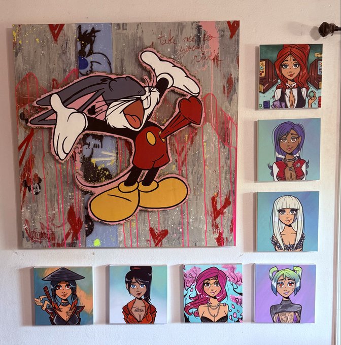 A wall display features a large pop-art style painting of an angry cartoon character with bones, surrounded by smaller paintings of various female characters with different hair colors and styles.