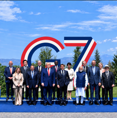Group of world leaders, including Donald Trump, posing for a photo in front of a large 'G7' sign outdoors.