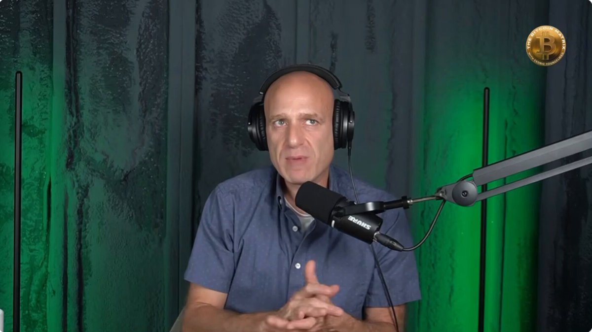 Matt Hogan, an expert in financial matters, is sitting at a desk with headphones on his head, suggesting he might be participating in a podcast or recording session. The image also shows a microphone attached to a radio station's equipment, indicating that Matt could be discussing financial topics related to ETFs and their advantages over self-custody. The post highlights the benefits of using ETFs for institutions, such as tax advantages, reduced trading costs, and easier reporting requirements.