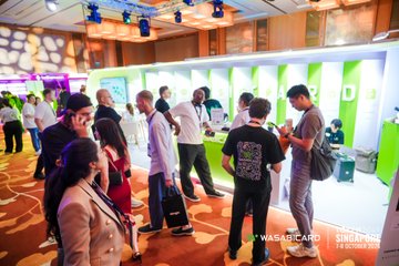 Attendees network at a WASD CARD conference event, with a 'SEASON TWO' booth visible in the background.