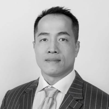 A black-and-white professional portrait shows a man in a pinstripe suit and patterned tie, identified as crypto investor Harry Yeh, the Quantum Fintech Group founder whose death in Paraguay is described in the accompanying article.