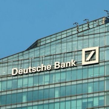 The image shows the glass façade of a Deutsche Bank office building displaying the company name and logo, accompanying news that Germany's largest bank is preparing to launch Bitcoin and Ethereum custody services.