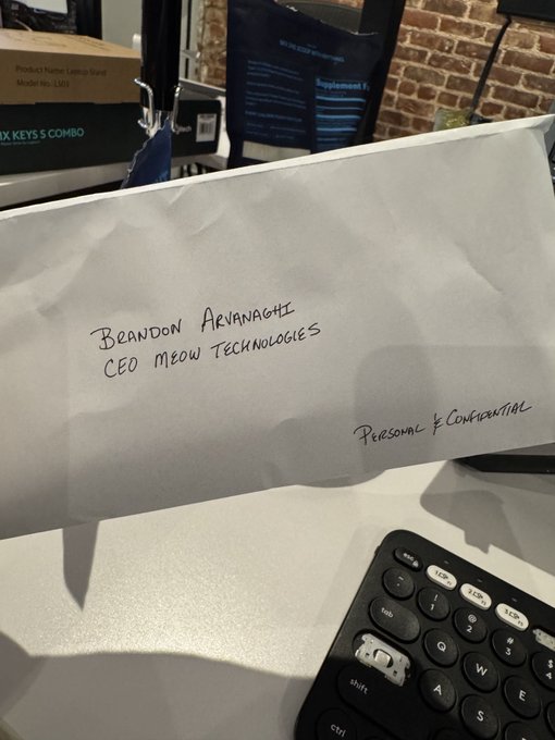 A handwritten envelope addressed to 'Brandon Arvanaghi, CEO Meow Technologies' marked 'Personal & Confidential', resting on a desk near a keyboard.